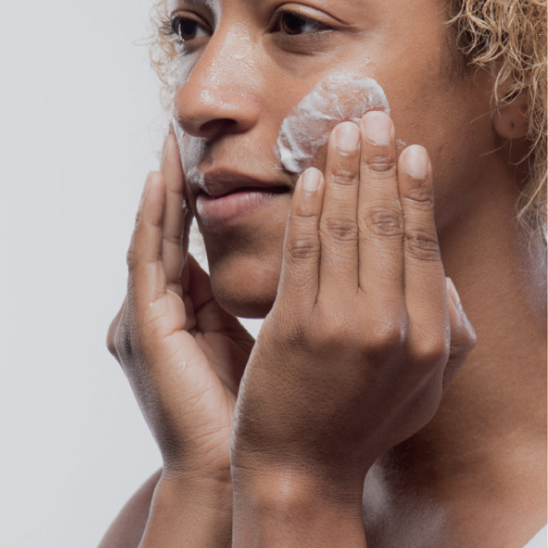 Woman exfoliating face